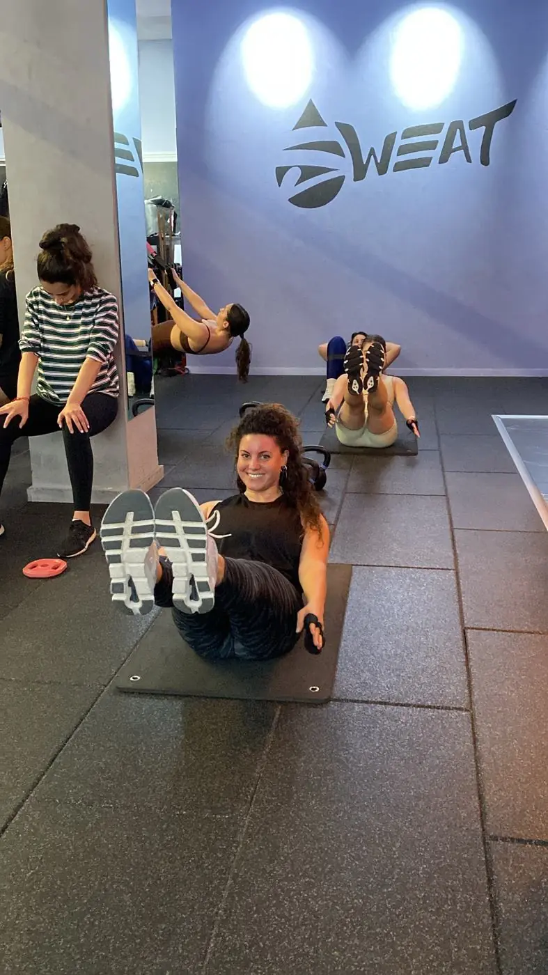 A member smiling during a session at SWEAT studio Ra'anana